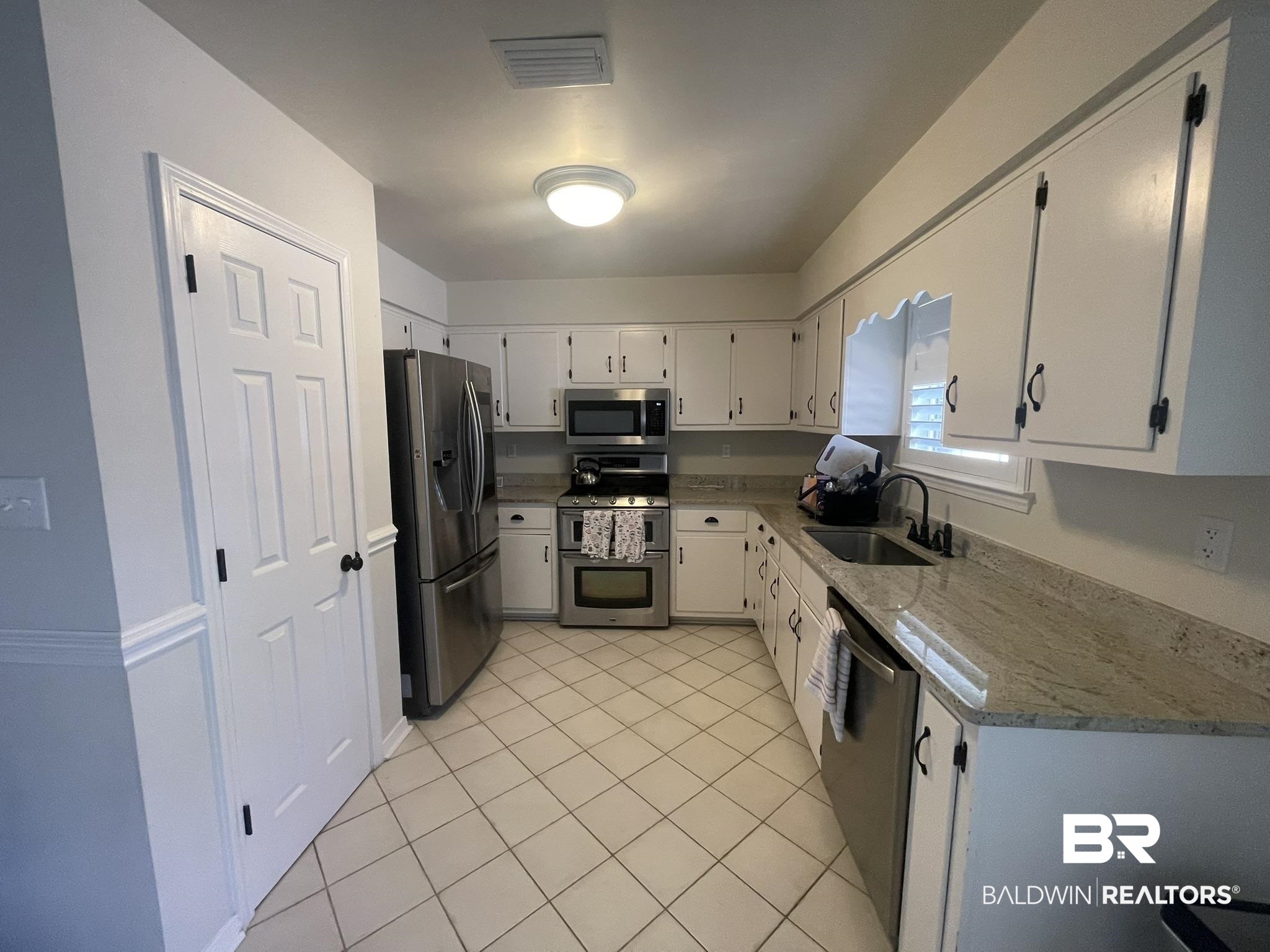 35405 Pine Road South Stapleton, AL 36578 - Photo 9 of 29 Kitchen with stainless steel appliances, light stone counters, light tile patterned floors, and white cabinets