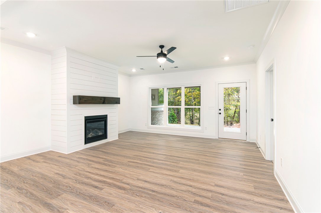 328 Point Road Westminster, SC 29693 - Photo 12 of 37 This bright living space features wood flooring, a fireplace, and a glass paneled door leading outdoors.