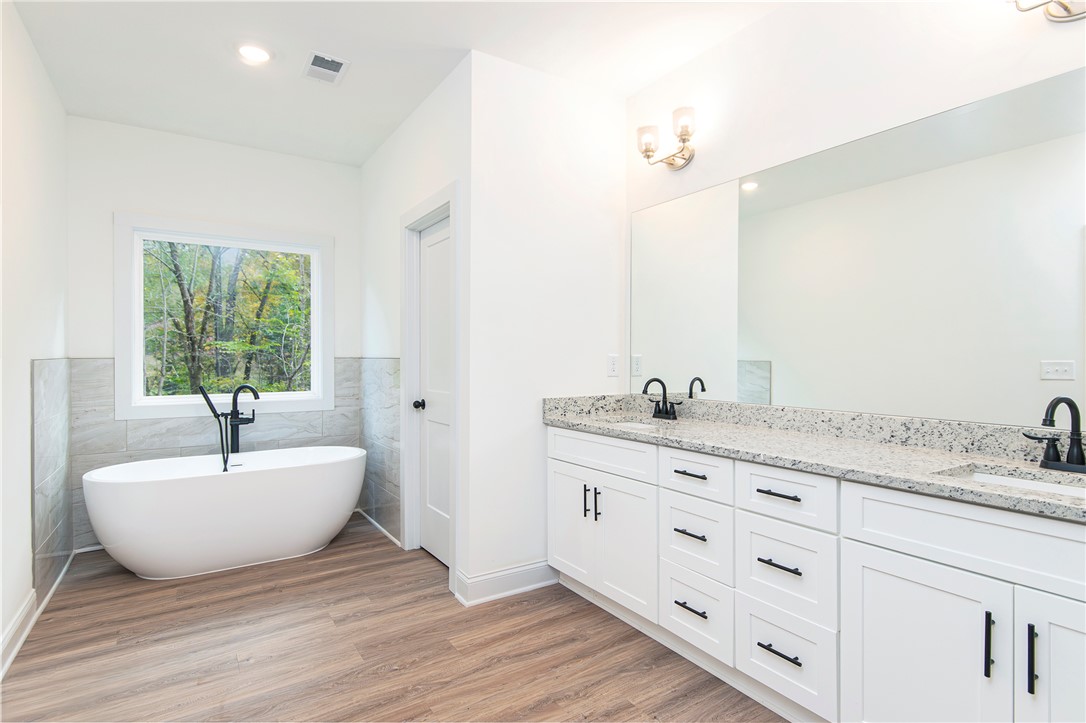 328 Point Road Westminster, SC 29693 - Photo 17 of 37 This spacious primary bathroom features a standalone tub with a view and an expansive double vanity.