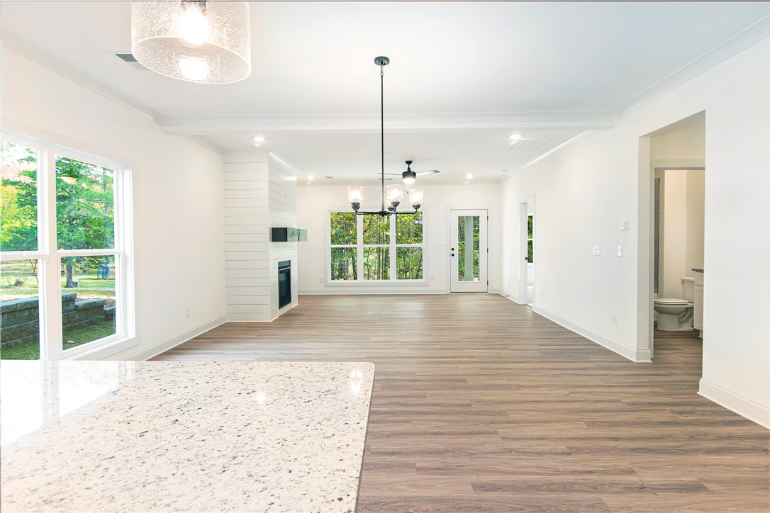 328 Point Road Westminster, SC 29693 - Photo 6 of 37 This bright, open-concept living space features warm flooring, large windows, and a sleek fireplace.