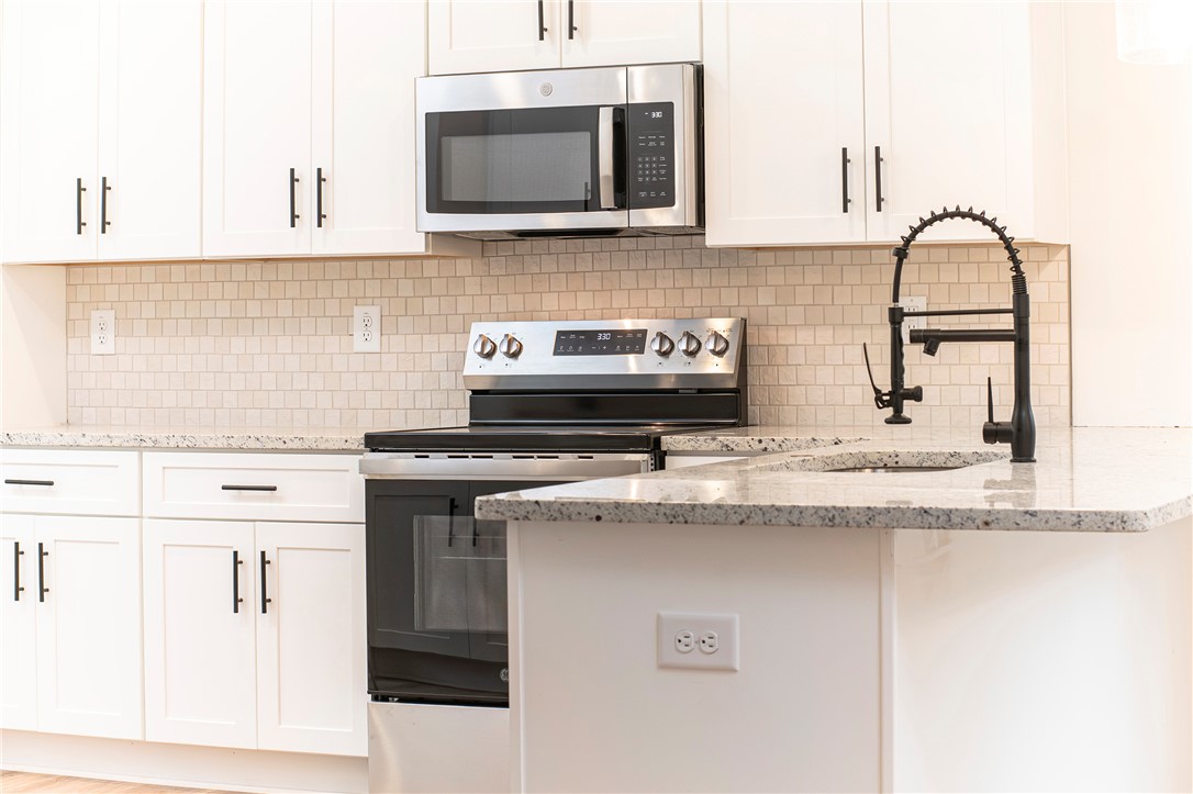 328 Point Road Westminster, SC 29693 - Photo 10 of 37 This modern kitchen features gleaming countertops, state-of-the-art appliances, and a stylish backsplash.