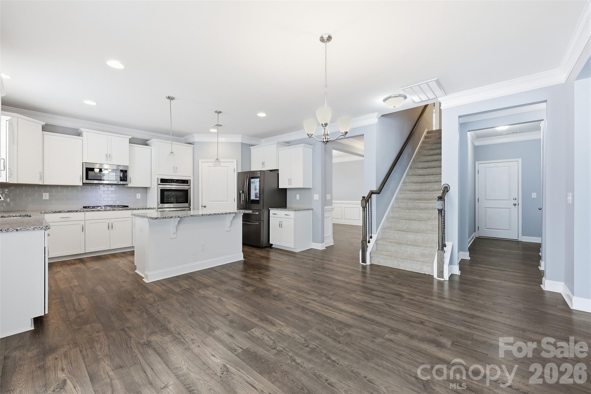 2314 Red Birch Way Concord, NC 28027 - Photo 12 of 44 a large kitchen with white cabinets stainless steel appliances and wooden floor