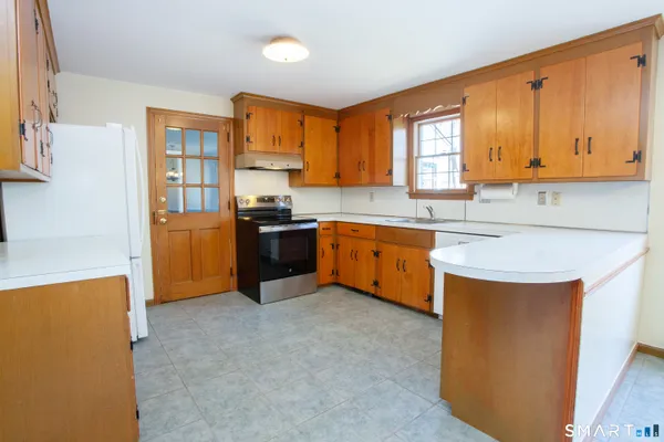 a kitchen with stainless steel appliances granite countertop a stove refrigerator sink and cabinets