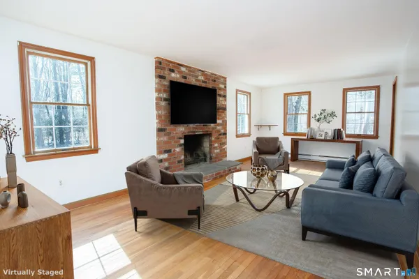 a living room with furniture a flat screen tv and a large window