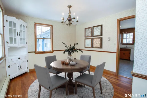 a dining room with furniture a chandelier and wooden floor