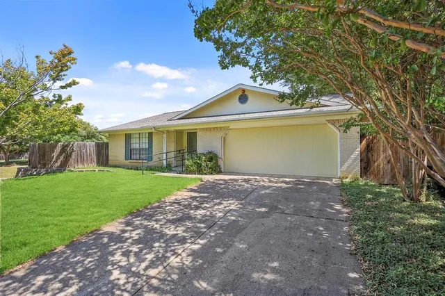 a front view of a house with a garden and yard