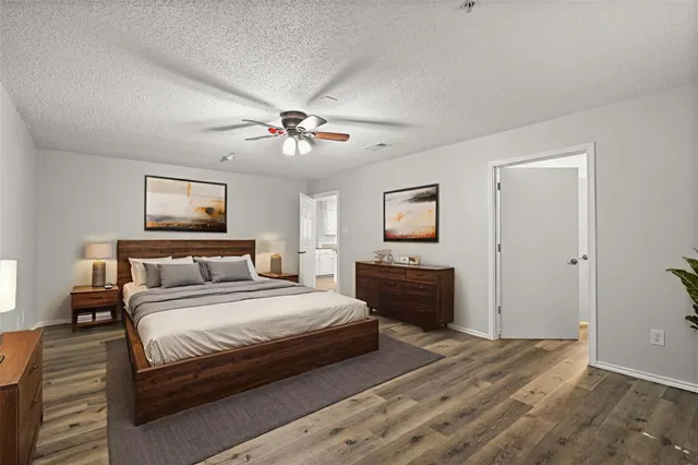 a bedroom with a large bed a chandelier and dresser