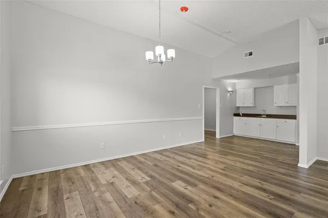 a view of empty room with wooden floor and ceiling fan