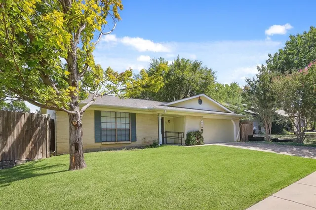 a front view of a house with a garden and yard