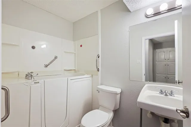 a bathroom with a toilet a sink and mirror