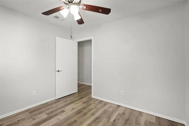 a view of an empty room and chandelier fan