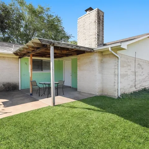 a view of a chair and table in backyard