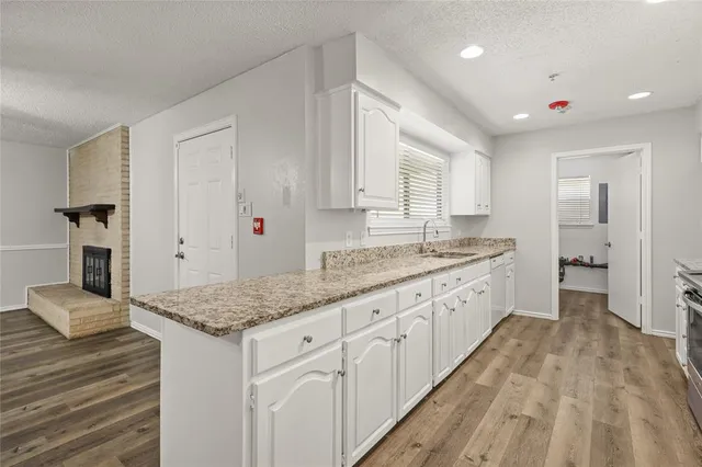 a kitchen with granite countertop sink stove and cabinets