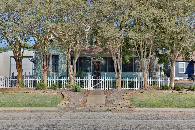 a view of a house with a fence in a forest