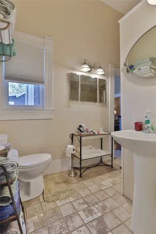 a bathroom with a toilet sink and mirror