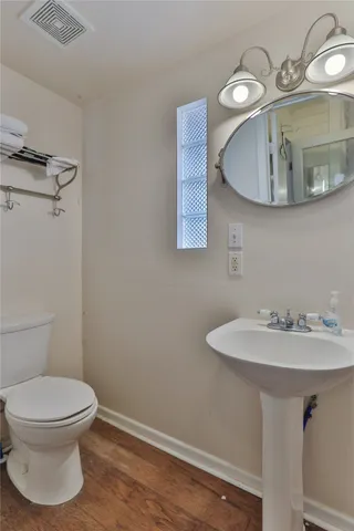 a bathroom with a toilet sink and mirror