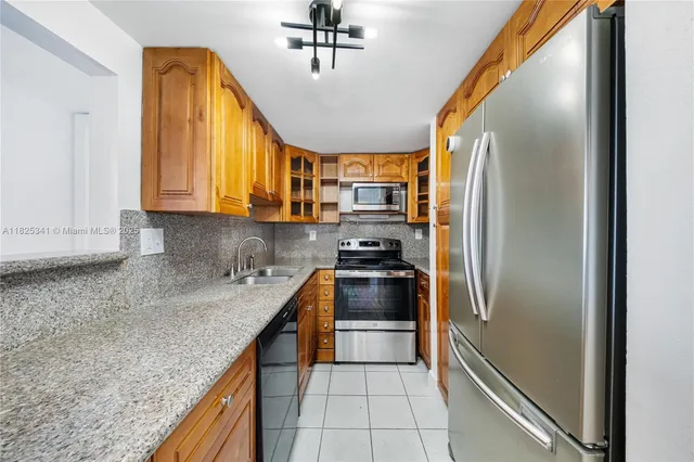 a kitchen with stainless steel appliances granite countertop a refrigerator a sink and a stove