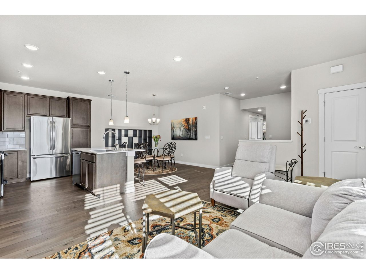 330 High Point Drive, Unit B103 Longmont, CO 80504 - Photo 7 of 18 a living room with lots of furniture and kitchen view