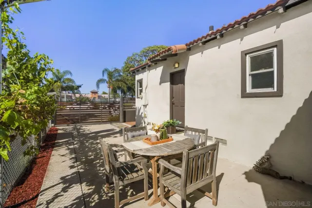 a view of a patio with table and chairs with wooden floor and fence