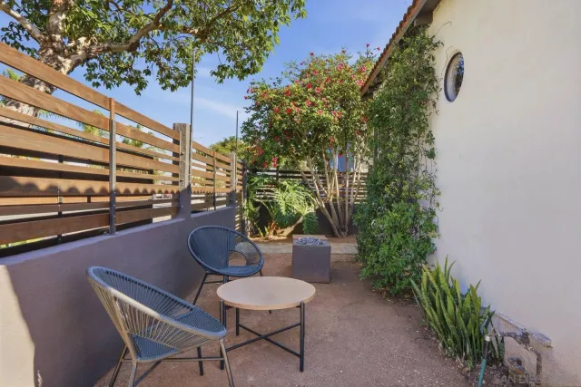 a balcony with chairs and a potted plant