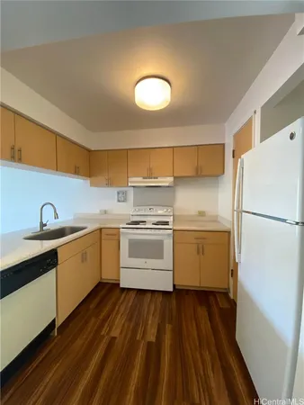 a kitchen with a white cabinets and wooden floor