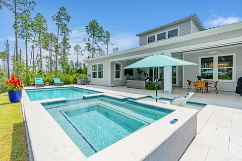 a view of a house with swimming pool and sitting area