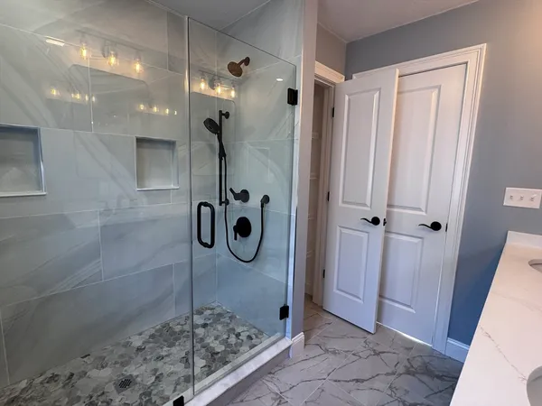 a bathroom with a shower and mirror