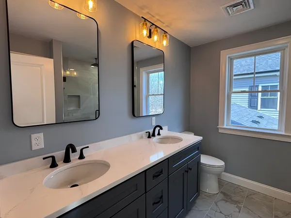 a bathroom with a double vanity sink and a mirror