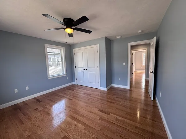 a view of empty room with wooden floor and window