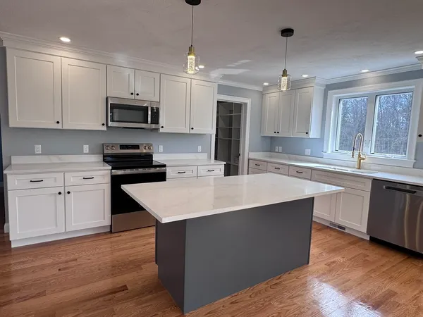a kitchen with stainless steel appliances granite countertop a sink a stove and a wooden floors