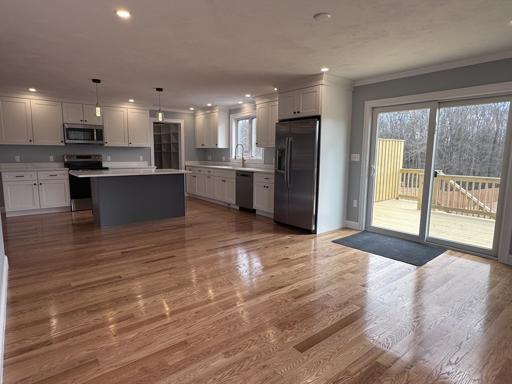 191 East Spring Street Avon, MA 02322 - Photo 5 of 33 a large kitchen with stainless steel appliances kitchen island granite countertop a refrigerator a sink dishwasher a stove and a large countertops with wooden floor