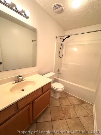 a bathroom with a granite countertop sink a toilet and shower