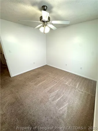 an empty room with a ceiling fan and a fan