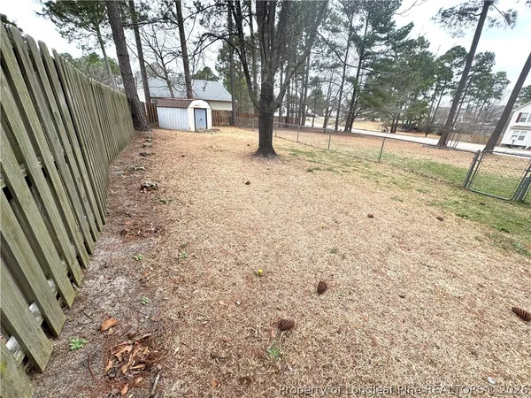 a view of a house with a yard and a tree
