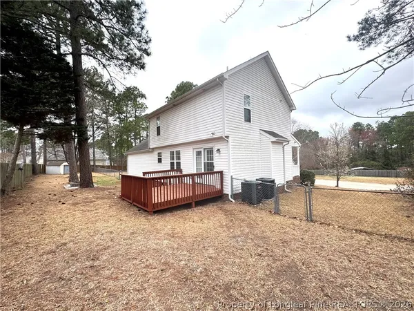 a view of a house with a deck and a yard