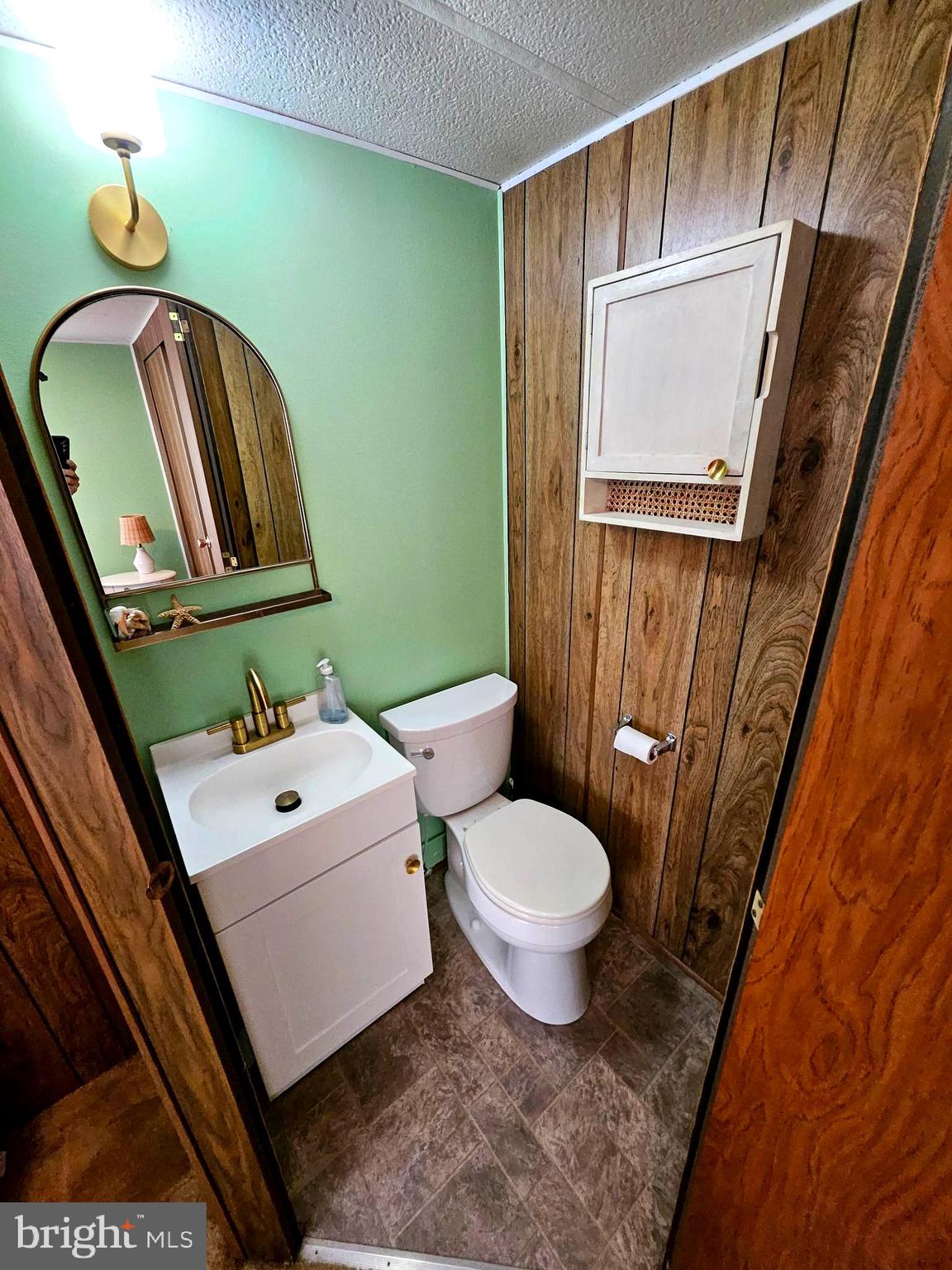 160 Clamshell Road Ocean City, MD 21842 - Photo 12 of 32 a bathroom with a toilet a sink a mirror and vanity