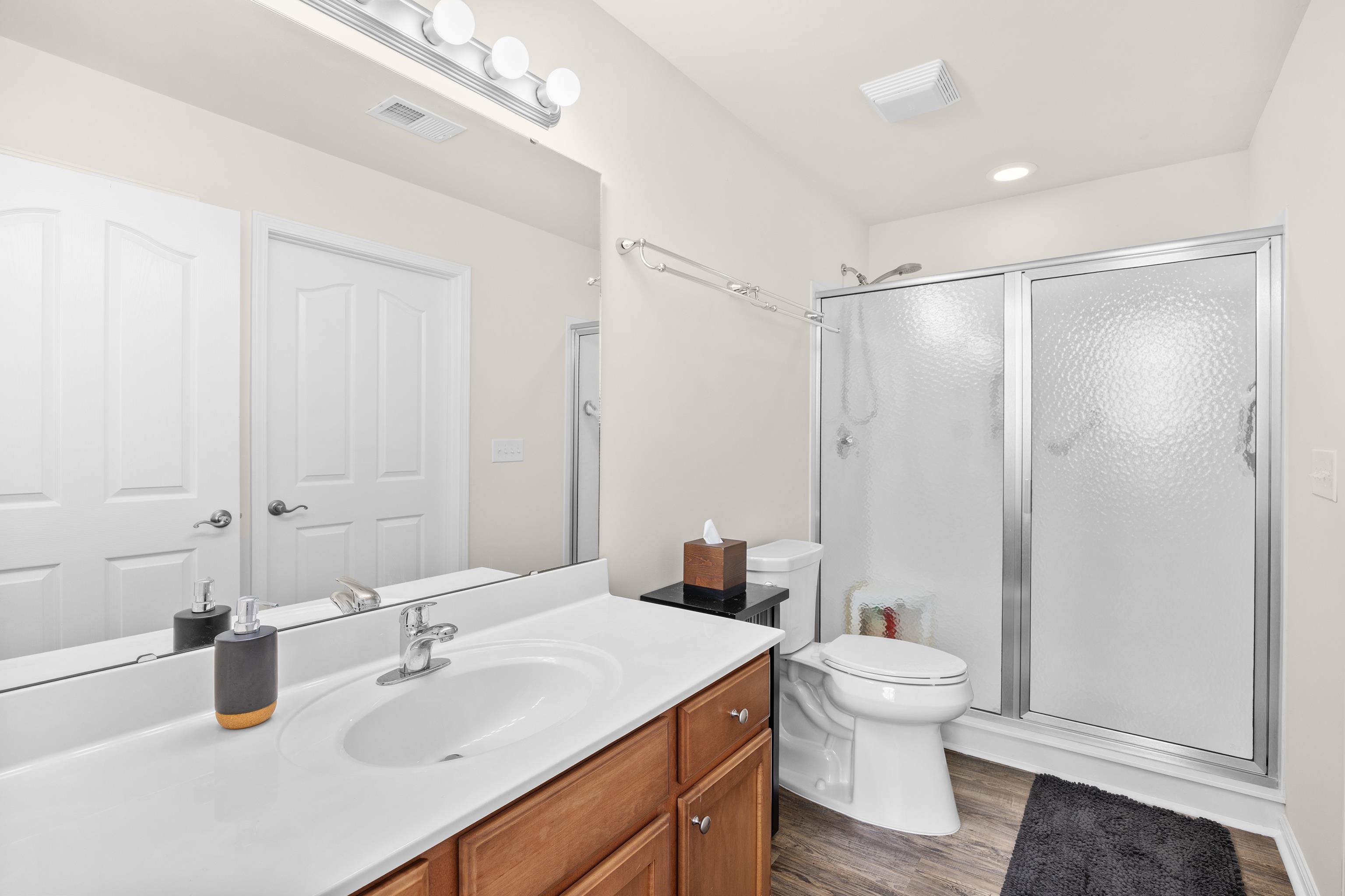 340 Arlington Circle, Unit 340 Murrells Inlet, SC 29576 - Photo 15 of 39 Features include a shower with a sliding glass door, a vanity, a high-rise toilet, a large walk-in closet, and a linen closet.