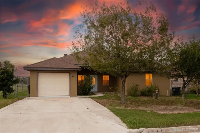 front view of a house with a yard and trees