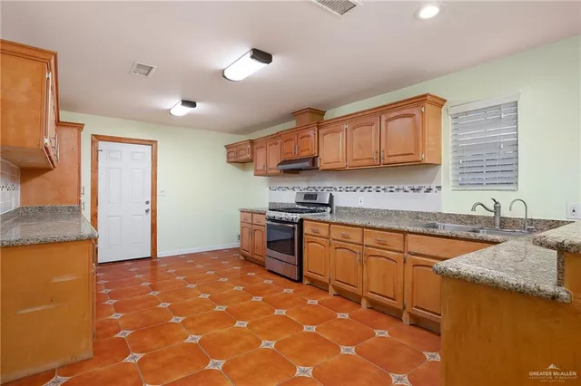 a kitchen with granite countertop a sink and cabinets