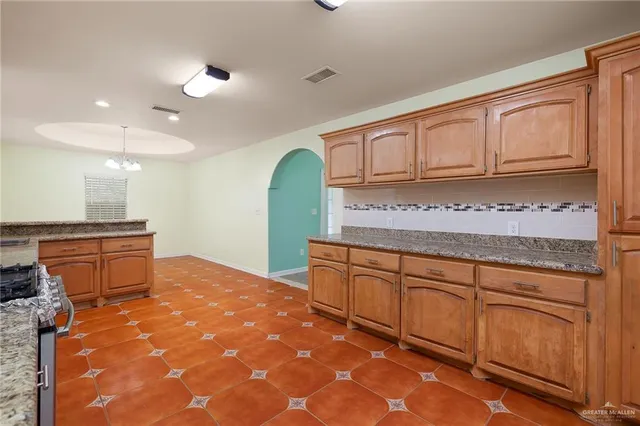 a kitchen with granite countertop a sink and cabinets