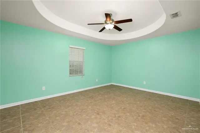 an empty room with a window and a ceiling fan