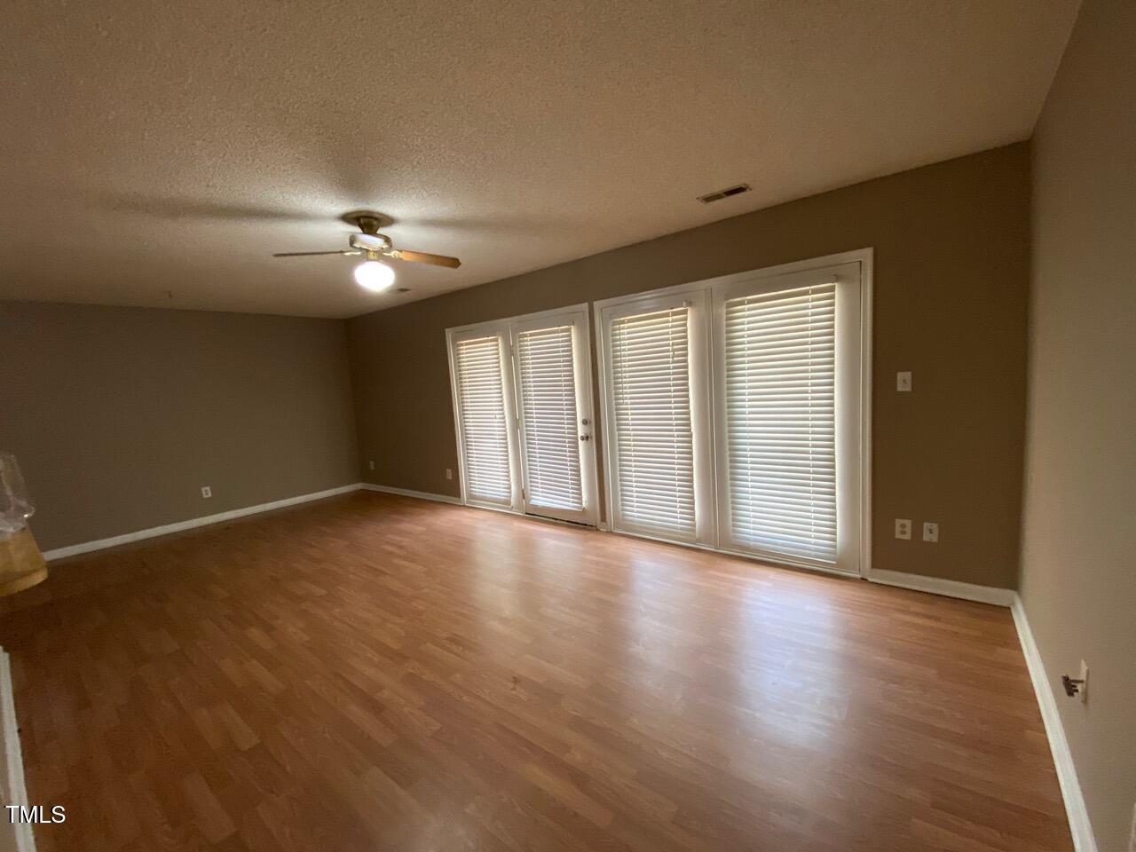 2011 Quaker Landing, Unit 102 Raleigh, NC 27603 - Photo 2 of 12 a view of an empty room with a window and wooden floor