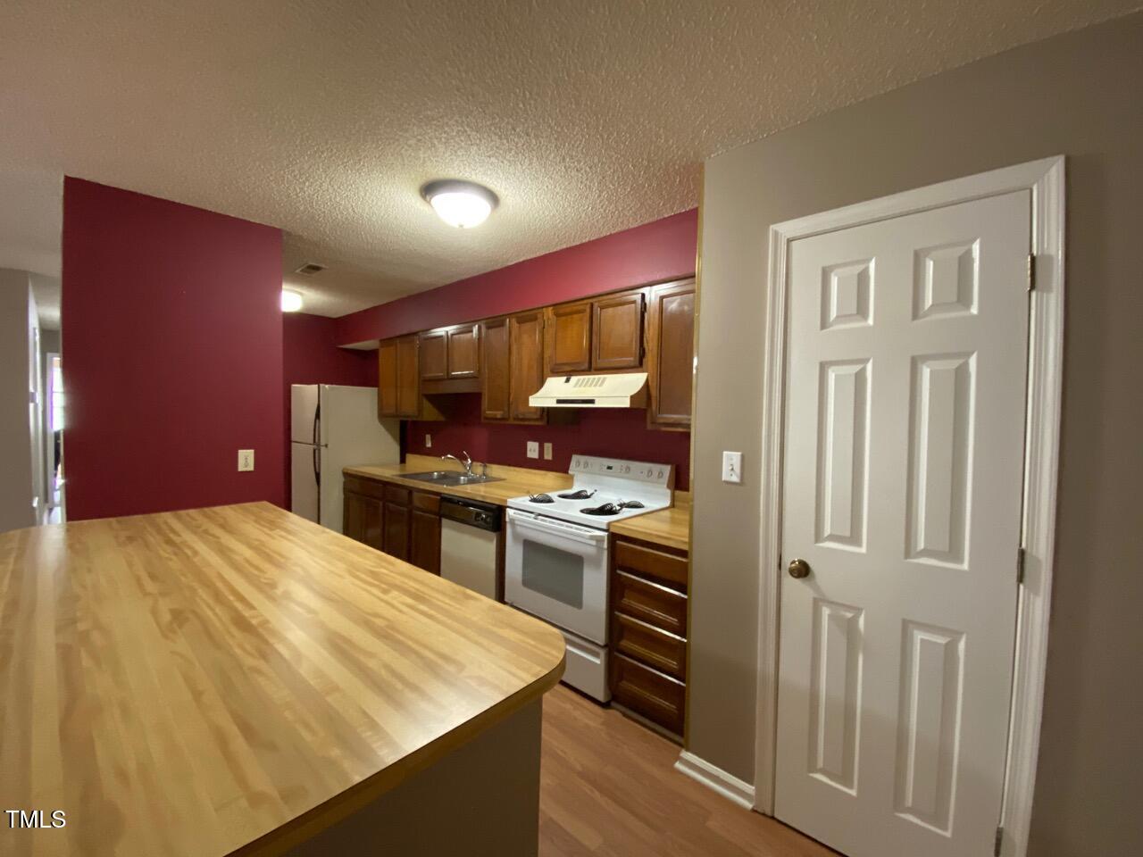 2011 Quaker Landing, Unit 102 Raleigh, NC 27603 - Photo 5 of 12 a kitchen with stainless steel appliances kitchen island granite countertop a refrigerator and a stove top oven