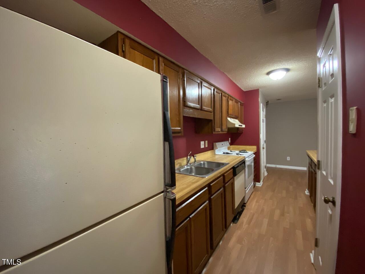2011 Quaker Landing, Unit 102 Raleigh, NC 27603 - Photo 6 of 12 a kitchen with stainless steel appliances a stove and a refrigerator