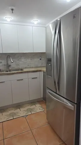 a kitchen with granite countertop a stove a sink and a white cabinets