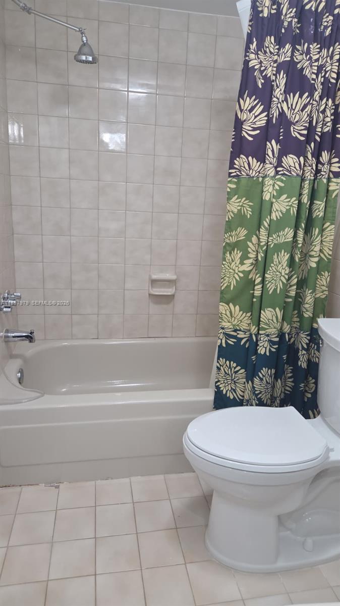 5249 Northwest 7th Street, Unit 418 Miami, FL 33126 - Photo 16 of 25 a bathroom with a toilet and a shower