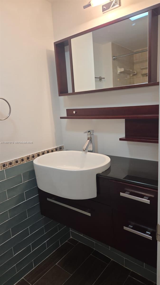 5249 Northwest 7th Street, Unit 418 Miami, FL 33126 - Photo 17 of 25 a bathroom with a sink and a mirror
