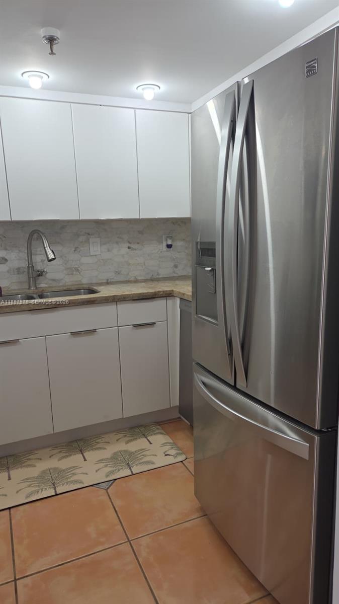 5249 Northwest 7th Street, Unit 418 Miami, FL 33126 - Photo 9 of 25 a view of a kitchen with a sink and a refrigerator