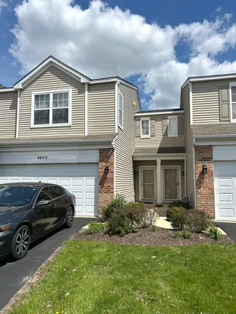 a view of a house with a cars park side of a road