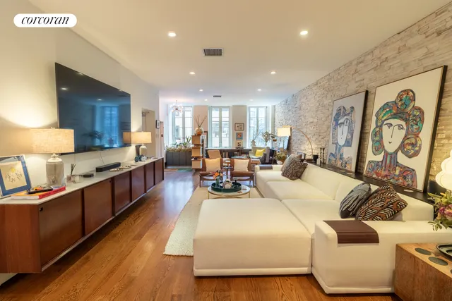 a living room with furniture kitchen view and a large window